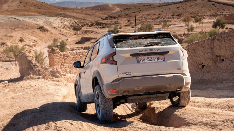 Dacia Duster rijdt over een woestijnweg, een robuuste SUV ontworpen voor offroad-avonturen