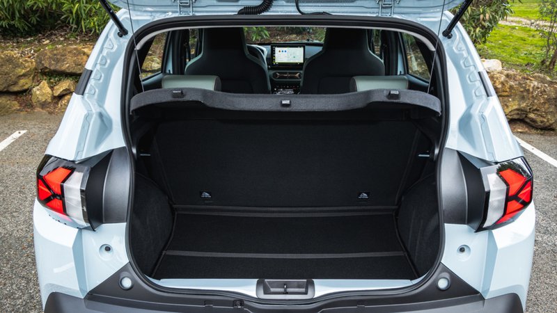 Le coffre de la Dacia Spring, ouvert pour montrer l'espace et le côté pratique.