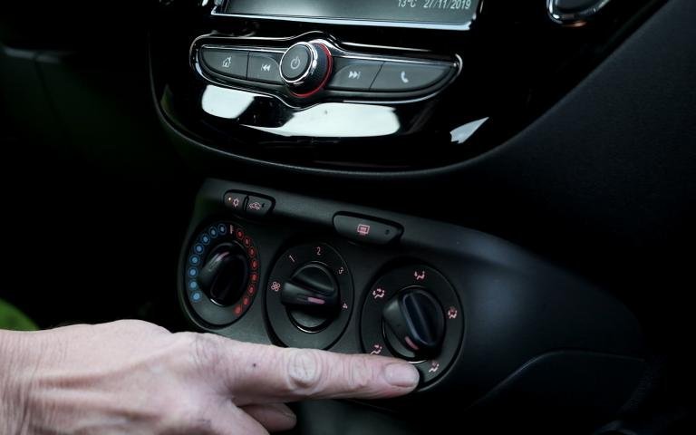 hand aan dashboard in de auto draait aan de knoppen