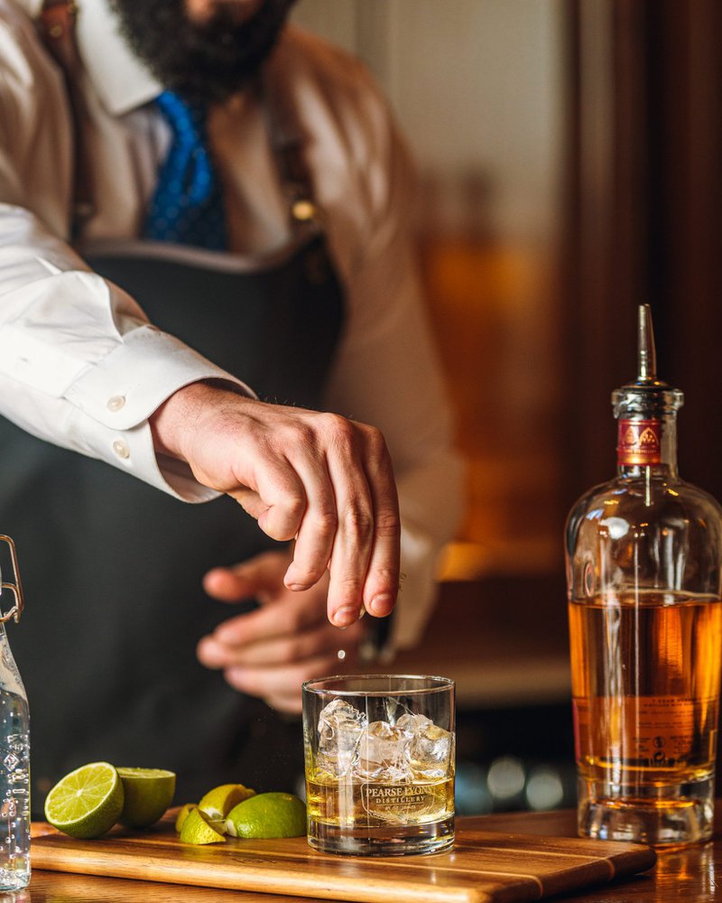 verre de whisky avec glaçons, bouteille et citron vert fraîchement pressé