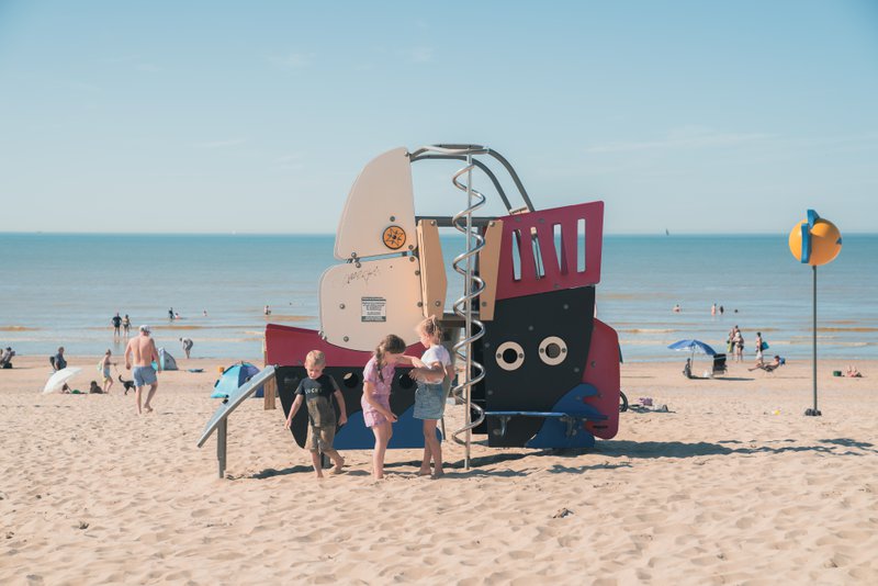 des enfants sur la plage, près d'un repère qui attire l'attention.