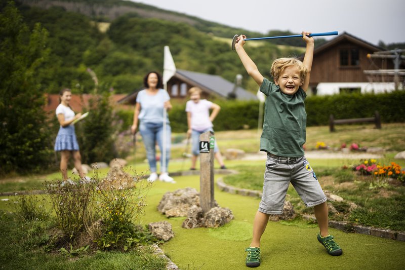 kinderen spelen een partijtje minigolf tijdens een autovakantie in Duitsland