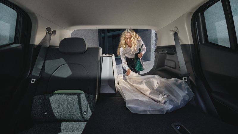 Coffre de la Kia EV2 avec banquette partiellement rabattue, montrant la modularité de chargement au quotidien.