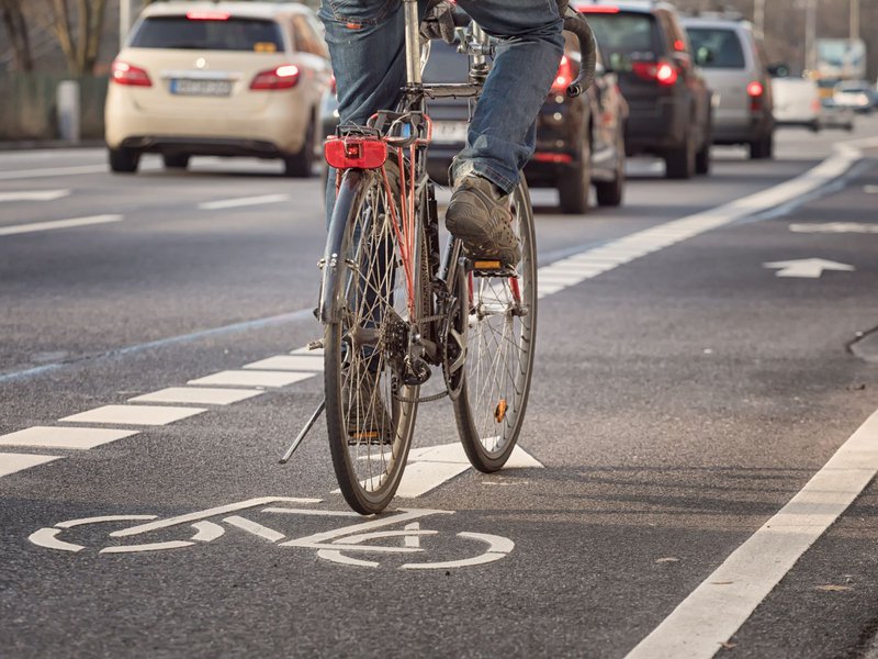 fietser op suggestiestrook naast druk verkeer