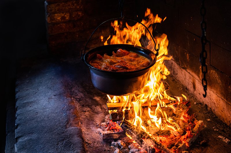 gerecht met paprika's met een zwarte pot op een haardvuur
