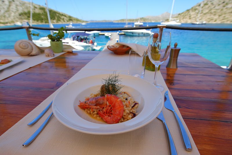 gerecht in bord met zicht op zee en bootjes en natuur in Kroatië