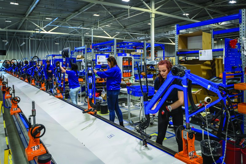lopende band in een fietsfabriek met verschillende mensen in het blauw