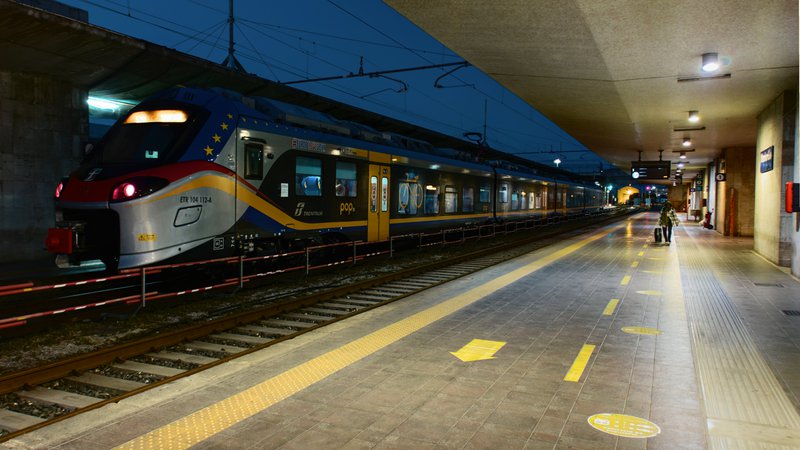 Trein staat 's nachts in een station, klaar om te vertrekken.