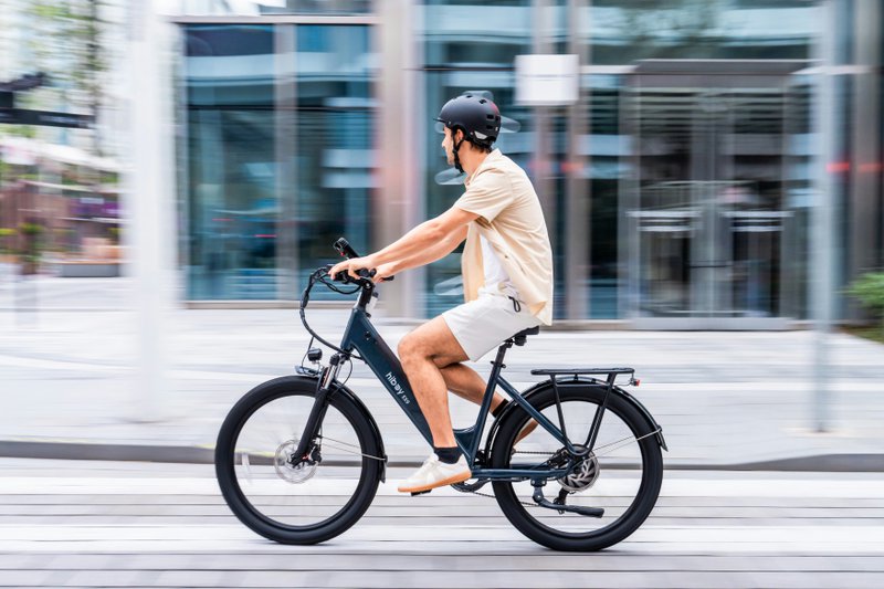 Mobilité - Cycliste roulant en ville sur un vélo électrique, avec arrière-plan flou.
