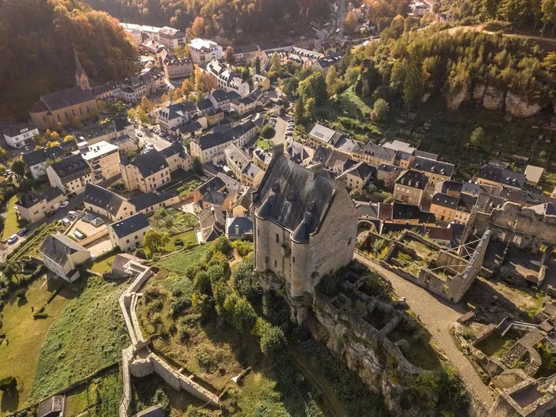 Photo aérienne d'un village avec un imposant château médiéval au centre.