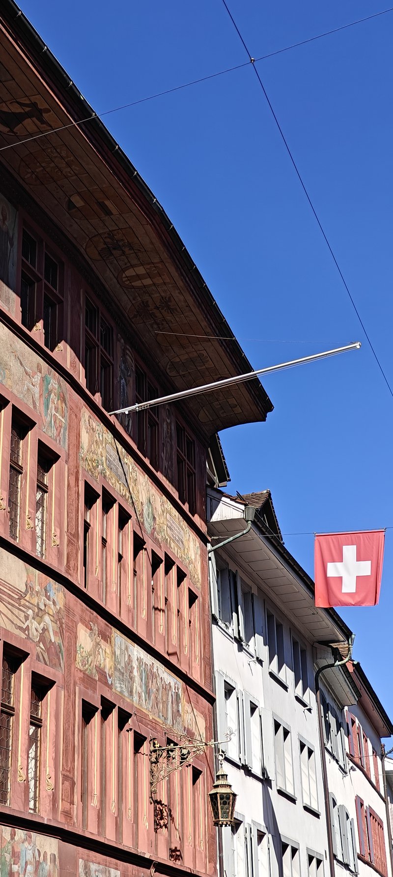 Façades de maisons dans un village en Suisse sur fond de ciel bleu.