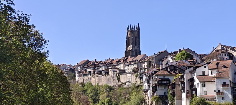 Village et tour d'une cathédrale sur fond de ciel bleu.