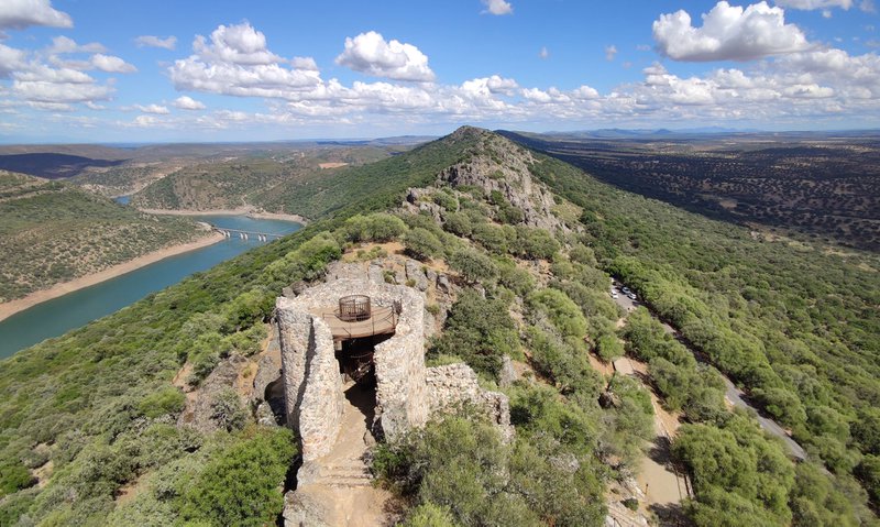 Espagne: paysage fait de roche et de vert bordé d'un cours d'eau, ciel bleu parsemé de nuages