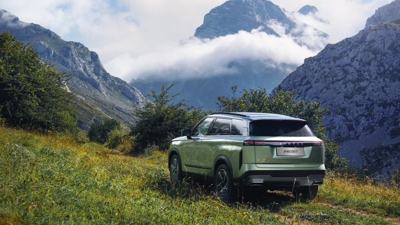 Jaecoo 7 vert vu de trois quarts arrière, stationné dans un décor de montagne au style outdoor.