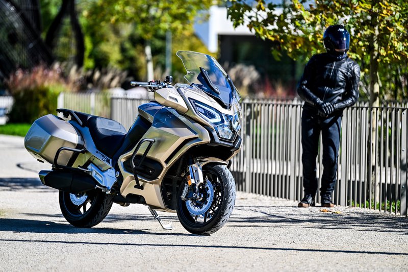 Mash GT750 staat geparkeerd, de bestuurder leunt tegen een hek