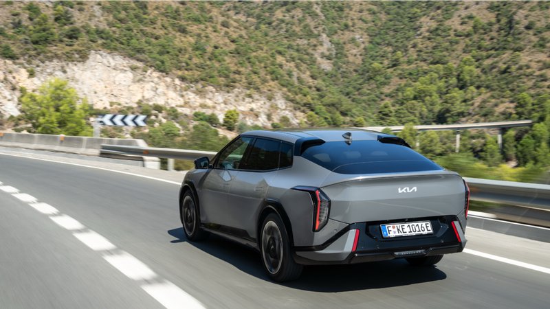Kia EV4 vue 3/4 arrière sur une route de montagne