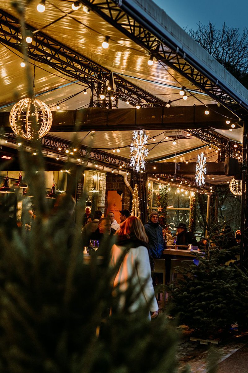 gezellig kerstkraam met feestelijk verlichting en warm geklede mensen