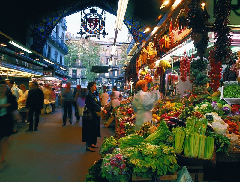 Een overdekte markt in Spanje, groenten op de voorgrond.