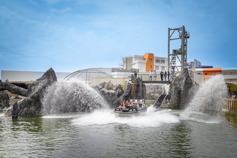 Attraction aquatique avec une barque sur rails qui plonge dans l'eau.