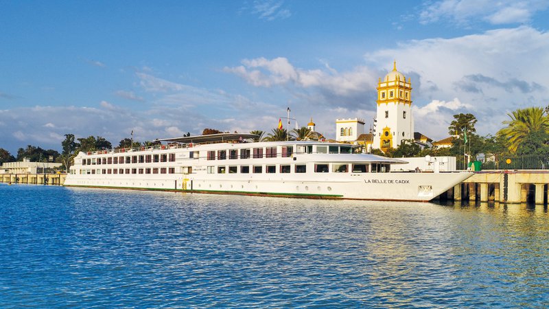riviercruiseschip op het water met toren op achtergrond