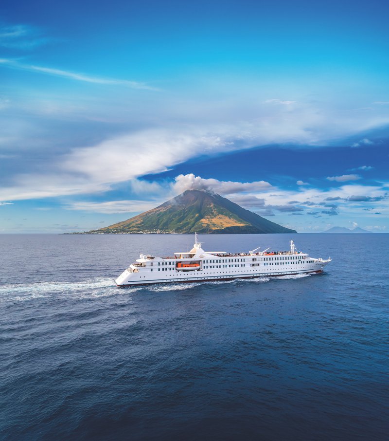 CroisiEurope zeeschip nabij een eiland met een spits berg