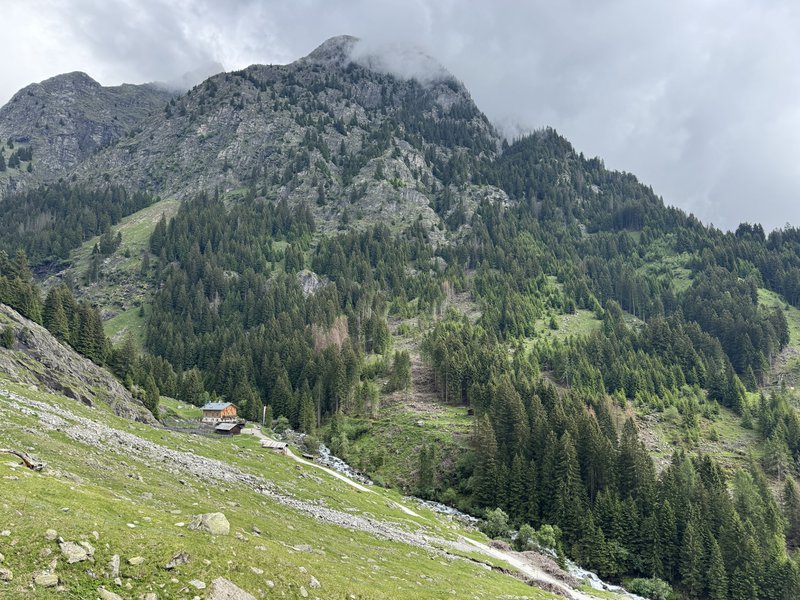 Refuge de montagne adossé à une paroi rocheuse.