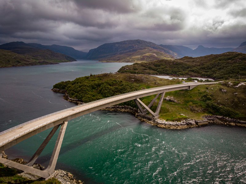 moderne brug over een brede rivier met een dreigende hemel - routes Europa
