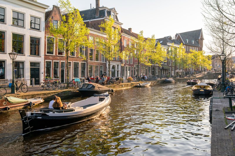des barques sur un canal, avec de majestueux bâtiments en arrière-plan.