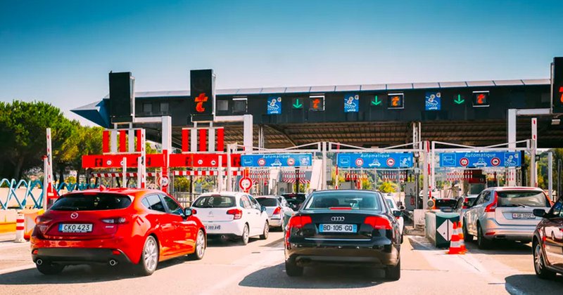 Druk verkeer bij een tolpoort op de Franse snelweg.