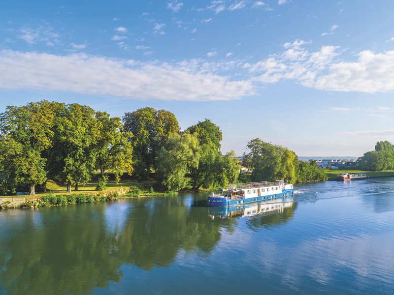 CroisiEurope, schip op het water langs beboste oevers