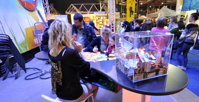 Mensen vullen op een beurs een formulier in voor deelname aan een wedstrijd.
