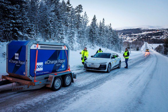 Solution de recharge mobile devant une voiture blanche dont la batterie est déchargée.