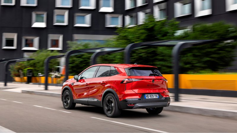 Vue arrière du Renault Symbioz E-Tech Esprit Alpine rouge circulant en ville.