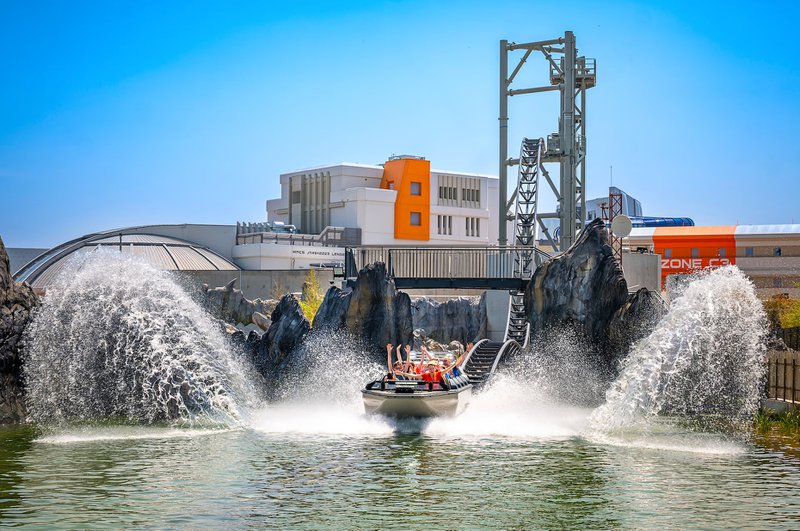 Bateau faisant des gerbes d'eau dans l'air avec des personnes sur une attraction aquatique au Futuroscope, à Poitiers.
