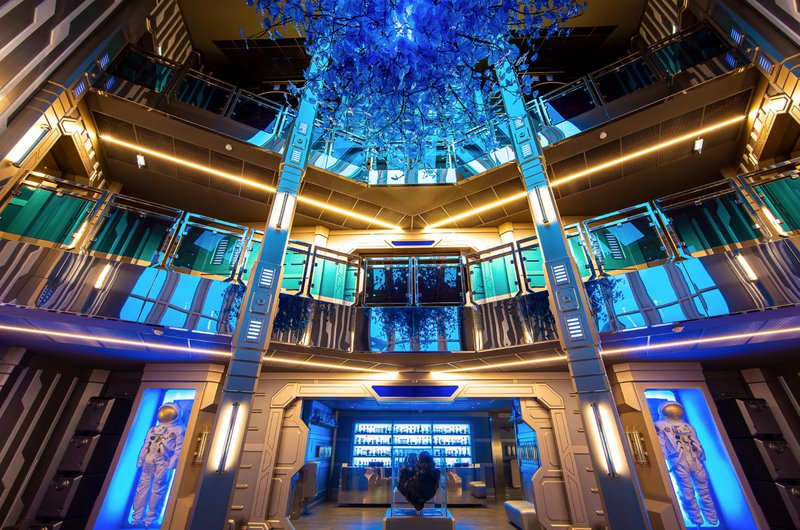 Hall d'hôtel futuriste éclairé de lumières bleues.
