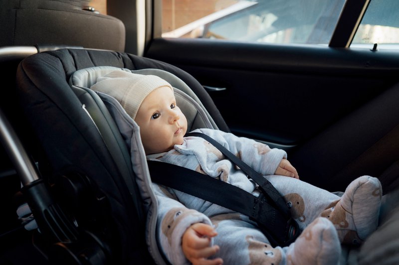 baby in autostoeltje op de achterbank van een auto