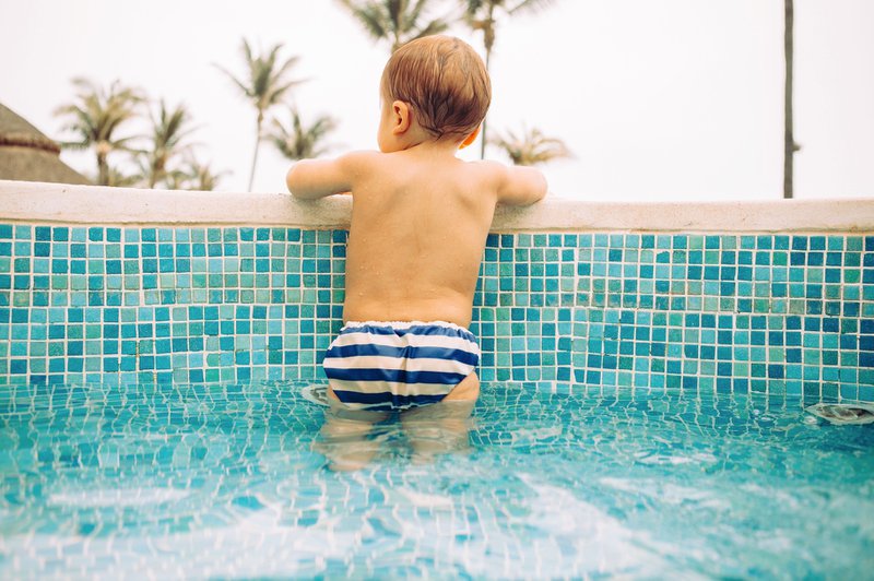 baby in zwembroek in een ondiep zwembad