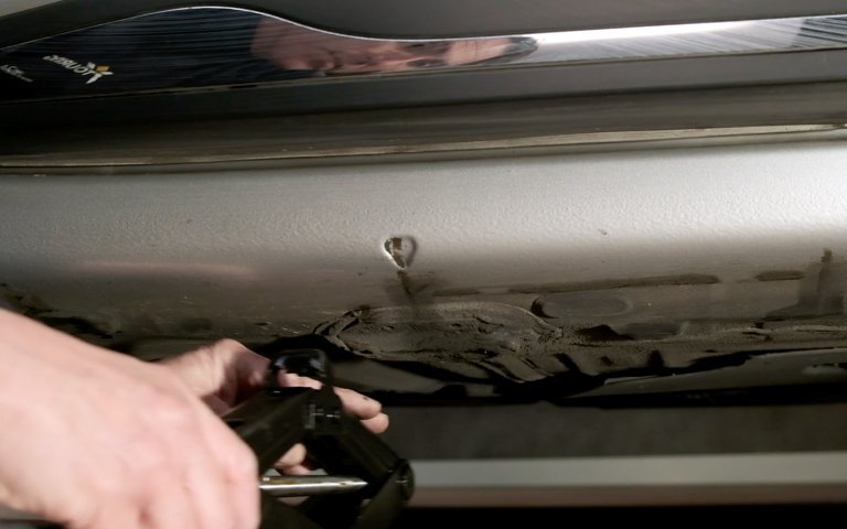 het plaatsen van de krik onder een auto