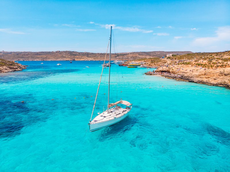 zeilboot op helderblauw water in Comino, Malta