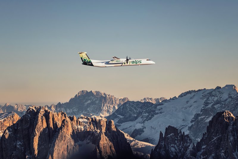 Un avion de SkyAlps qui survole les sommets.