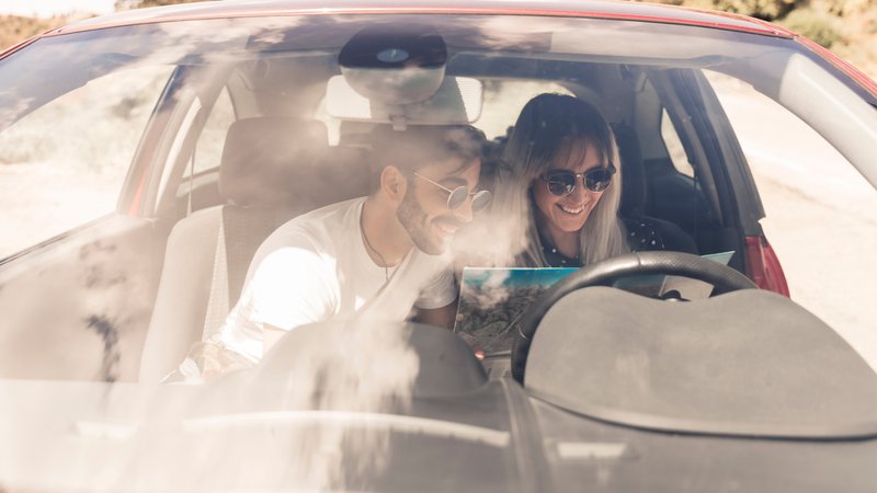 Canicule, un couple dans sa voiture qui regarde une carte routière. Sous la canicule