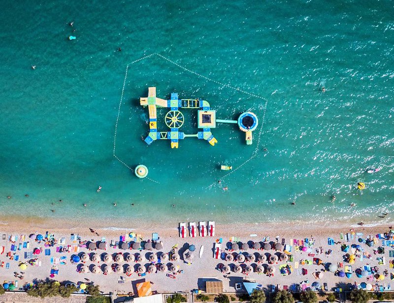 luchtfoto van druk strand en waterpark in de zee - vliegvakantie Kroatië