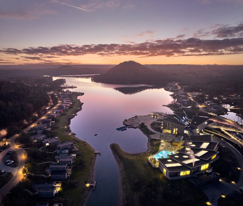 Luchtfoto bij valavond van een vakantiepark aan het water in Kempen en Maasland.