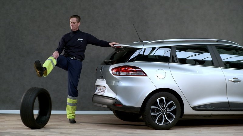 wegenwachter aan de achterkant van een auto houdt met zijn boet een band tegen