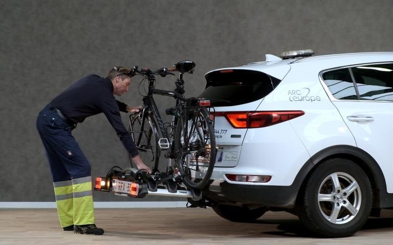 porte-vélos avec 1 vélo sur l'attelage d'une voiture blanche