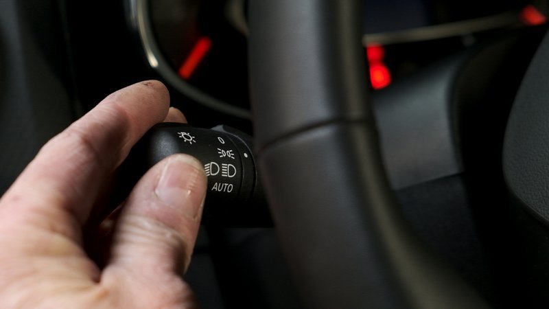 une main tourne un bouton situé sur le volant.