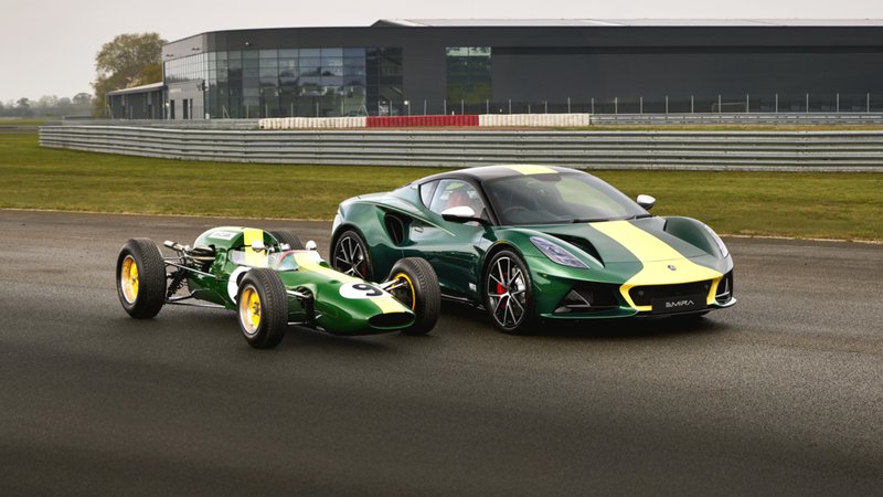 Lotus Emira Clark Edition verte et jaune posée à côté d’une monoplace de course Lotus historique.