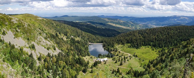 klein meer in berglandschap met kronkelende weg - routes Europa