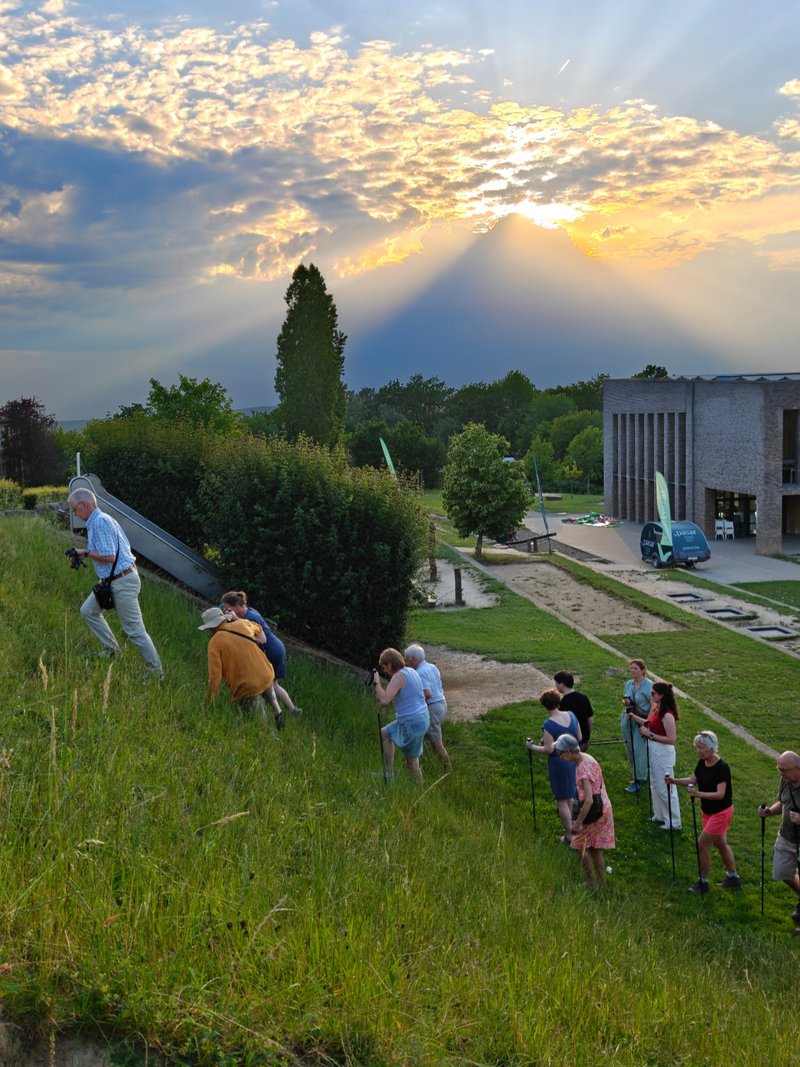 Wandelaars beklimmen een steile helling in de avondzon