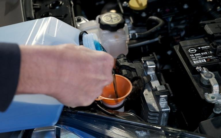 Remplissage du réservoir de liquide lave-glace à l'aide d'un petit entonnoir